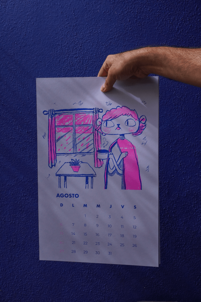 A hand holding a colorful illustration of a calendar for August, featuring a character by a window with a plant on a table, against a blue wall.