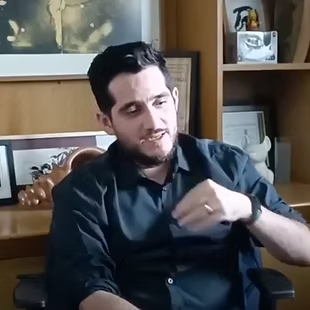 Carlos Eduardo Hernández, ilustrador mexicano, hablando en su estudio con obras de arte y libros de fondo.