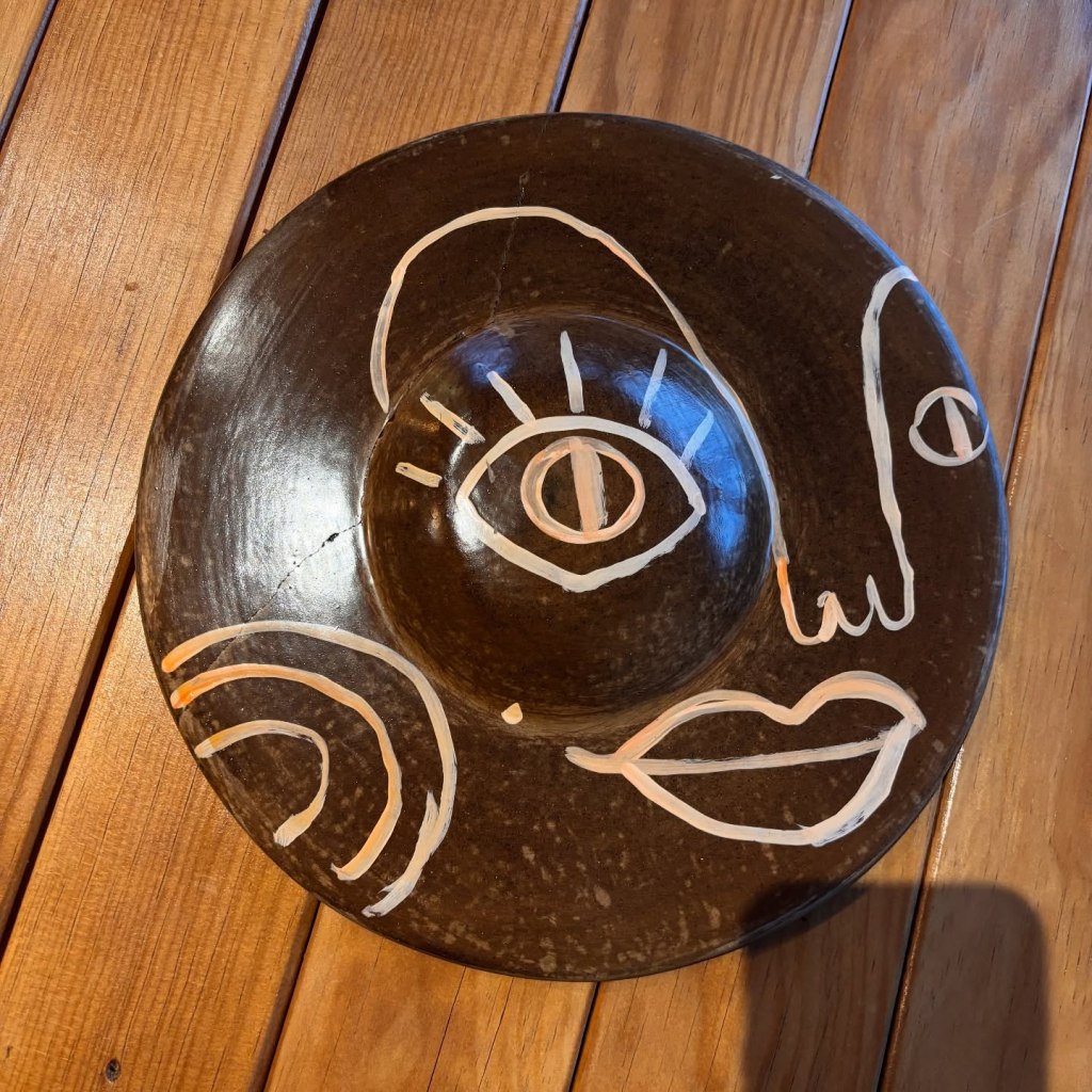 Plato de barro negro oaxaqueño con rostro abstracto pintado a mano, restaurante Komunal Colima
