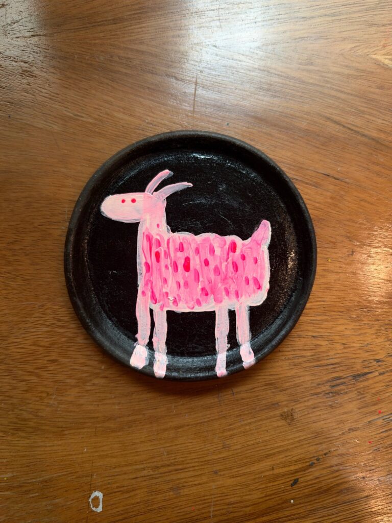 Cabra pintada en acrílico rosa magenta sobre plato de barro negro oaxaqueño